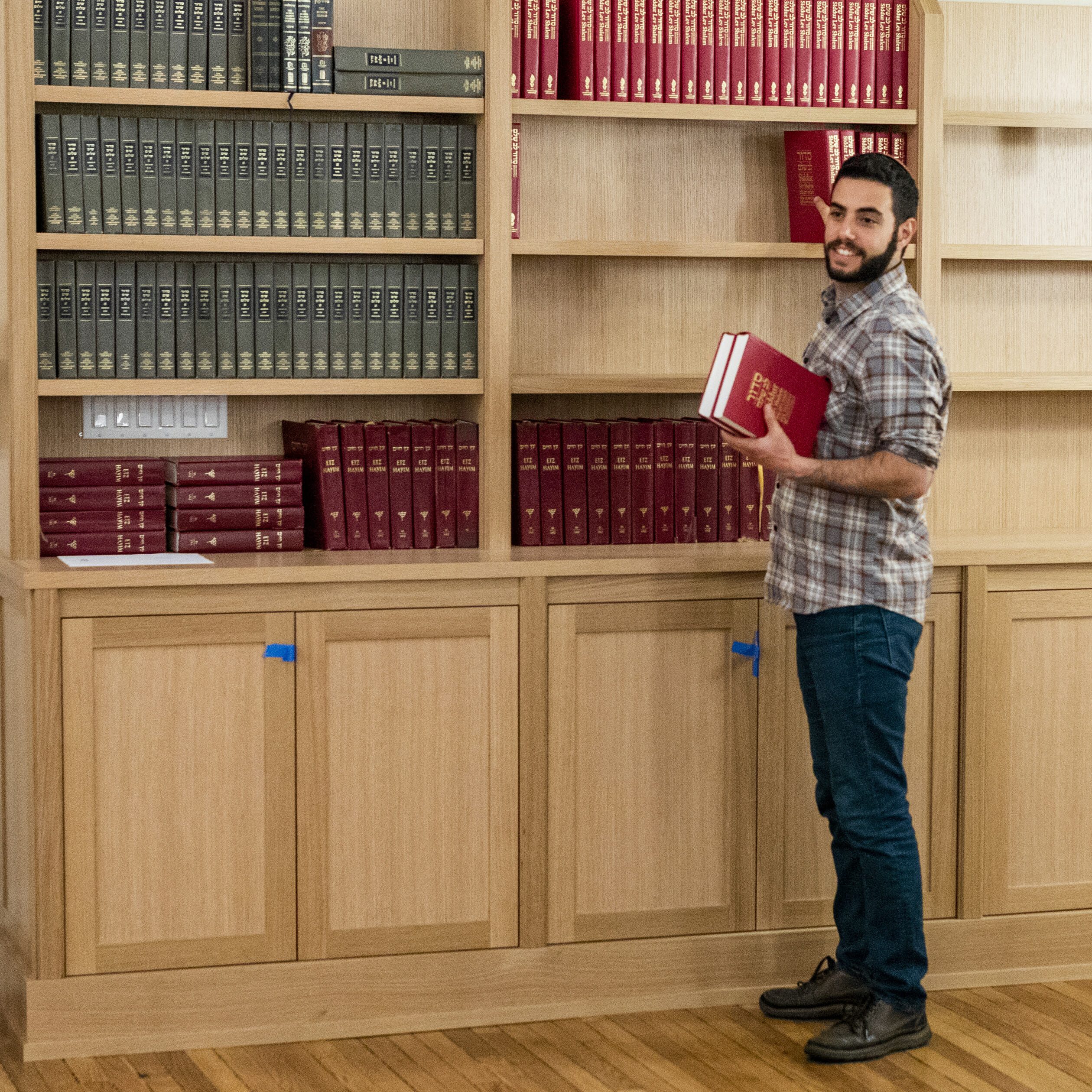 hebrew teacher grabbing books off shelf